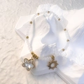 Dettaglio bracciale con perle bianche opache e ciondoli a forma di stella e sole - Bianco - Stella Trasparente
