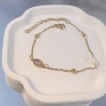 Detail eines vergoldeten Edelstahlarmbands mit Marquise-Edelstein und Barockperle - Oval-Rosa