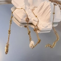 Detailweergave van gouden ketting met kristallen druppel en parels op witte stenen voet - Waterdruppel - Transparant