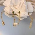 Dettaglio collana dorata con gemme verdi marquise e perle bianche su decorazione in pietra - Ovale-Verde