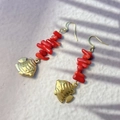 Detail shot of tropical fish earrings with red coral beads on a stone surface - Red