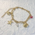 Detalle de dijes de estrella de mar dorada y perlas en pulsera doble de acero - Estilo Estrella De Mar