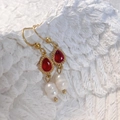 Détail de boucles d'oreilles dorées avec strass rouges et perles d'eau douce baroques - Goutte d'eau-Rouge