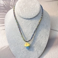 Close-up of colorful mushroom pendant with vibrant three-color braided rope necklace - Yellow