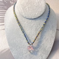 Close-up of colorful braided rope necklace with a cute pink resin mushroom pendant - Pink