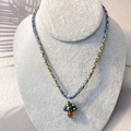 Detail of colorful woven cord necklace with a handcrafted glass mushroom pendant on a stand - Black