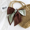 Chocolate brown and mint green satin scarf tied as a bow on a straw handbag - Green & Caramel