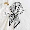 Elegant black and white geometric silk scarf tied in a bow on a white shirt - White Base Fine Line (1)
