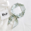 Narrow long silk scarf with light green floral pattern tied in a bow on a white shirt - Fresh Magnolia Branch (11K)