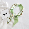 Narrow silk scarf with green avocado print tied as a hair ribbon on white background - Emerald Avocado Style (23K Avocado Emerald Green)