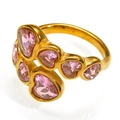 Close-up of golden crossover ring featuring six pink heart-shaped zircon gemstones - US 6 / Gold Pink Zirconia