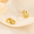 Detailansicht goldener Creolen mit geometrischem Muster auf weichem, strukturiertem Stoff - Gold (HL-92 Gold)