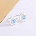 Boucles d'oreilles flocon de neige avec zircon bleu, vues sous un angle de 45 degrés - Style à Tige