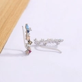Orecchini ear crawler in argento con zirconi multicolore su sfondo in legno minimalista - Oro Bianco