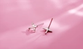 Macro shot of 925 sterling silver airplane stud earrings on a soft pink background - Airplane Style (157)