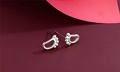 Macro shot of silver baby footprint stud earrings featuring a high-polish finish - Footprint Style (F1)