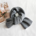 Thick grey striped knit scarf for women shown folded on a soft white fabric surface - Gray