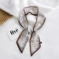 Elegant leopard print narrow silk scarf tied in a bow on a white textured background - Chiffon Leopard Print White