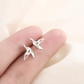 Minimalist silver paper crane stud earrings with sparkling crystals shown on fingers - Origami Crane Style (C4)