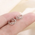 Primer plano de un ear cuff de ADN hélice plateado en la punta del dedo para referencia - Estilo de Doble Hélice de ADN (A37)
