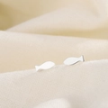 Orecchini a perno a forma di pesce in argento su una superficie in tessuto beige - Argento