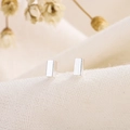 Minimalist silver rectangular stud earrings for men and women on linen background - Silver
