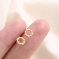 Minimalist gold beaded hoop earrings shown on a finger for scale on soft fabric - Golden Bead Ring (B211)