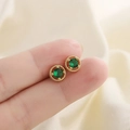 Vintage emerald zircon stud earrings in gold plated silver held between fingers - Gold Emerald Green Stud Earrings (C33)