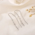 Elegantes pendientes largos de borla en plata de ley S925 sobre fondo de tela blanca - Plateado