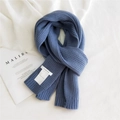 Blue knit scarf with thick ribbed texture and white brand label on white fabric - Blue