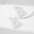 Dettaglio di orecchini a perno fatti a mano con perline bianche e design geometrico a triangolo - Bianco