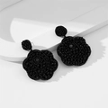 Dettaglio macro di orecchini a rosa con perline nere su espositore bianco moderno - Nero