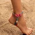 Bohemian colorful resin chain anklet with natural shell and tassels on a sandy beach background - Colorful