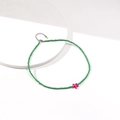 Macro shot of green seed bead necklace featuring a pink starfish pendant and metal clasp - Green