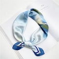 Élégant foulard en soie dégradé bleu ciel avec imprimé paysage posé sur un magazine chic - 20 Vue Lointaine