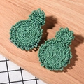 Handmade green seed bead earrings with bohemian woven design on a rustic wooden background - Green