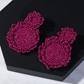 Handmade magenta seed bead earrings with layered disc design on a black pedestal - Fuschia
