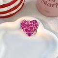 Translucent pink heart acrylic phone grip with dark pink heart patterns on a tray - Rose Red