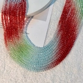 Nahaufnahme von facettierten Kristallperlen mit Regenbogenverlauf auf Plüschstoff - 4mm (Ca. 120 Stk./Strang) / Verlauf Rot Grün Blau
