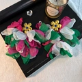 Detailed macro view of handmade layered chiffon flower earrings with golden core details - Colorful