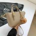 Beige bucket bag in lychee pattern leather with golden hardware and plush charm - Khaki With Pendant