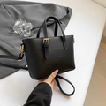 Compact black bucket bag in lychee pattern leather with gold hardware being held - Black Single Bag