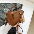 Dark brown pebble leather bucket bag with top handle and cute plush charm detail - Yellowish Brown With Pendant