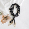 Élégant foulard étroit en soie à rayures noires et beige noué sur un tissu texturé - Cadre à Lignes Fines Noir