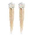 Détail macro de boucles d'oreilles à longs pompons dorés et strass brillants avec opales - Blanc AB