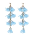 Dettaglio di orecchini a fiore in tulle azzurro con finitura in metallo e lunghe nappe - Blu