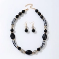 Set di gioielli bohémien con perline nere e trasparenti su sfondo bianco - Parure collana e orecchini / Nero