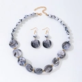 Set di gioielli bohemian con perline in resina marmorizzata e dettagli dorati su bianco - Parure collana e orecchini / Grigio