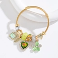 Close-up of gold beaded bracelet with green heart crystal and Love heart charms - Green