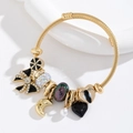 Bracciale dorato con ciondoli a farfalla, cuore nero e cristalli su elegante base bianca - Nero